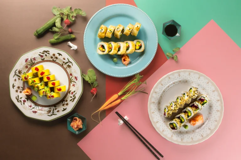 Fotografía gastronómica editorial de tres variedades de sushi en platos de porcelana sobre fondo geométrico de colores — Jose Fonseca Medellín