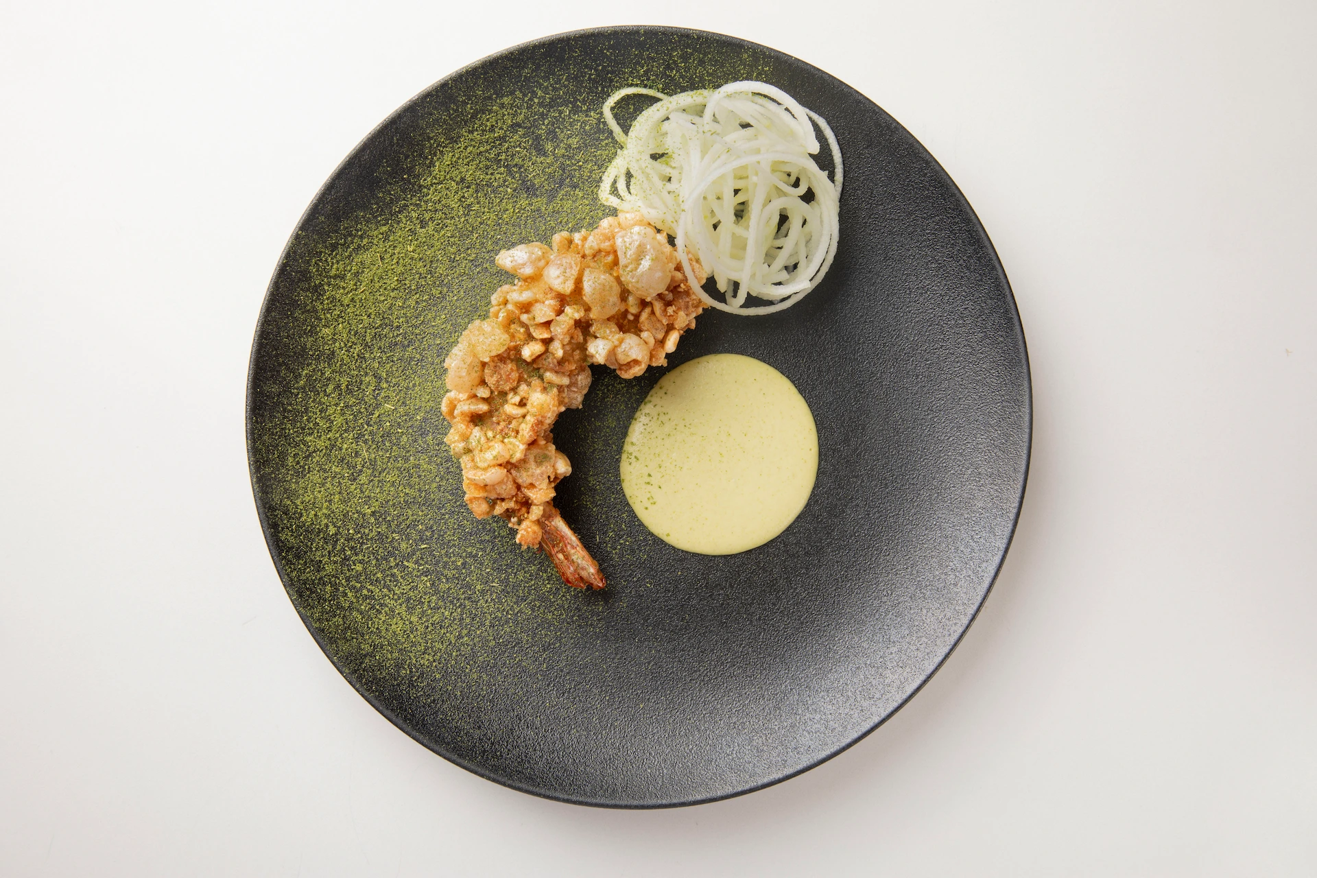 Fotografía gastronómica de camarón tempura con espuma cremosa y fideos de daikon en plato negro de alta cocina — Medellín