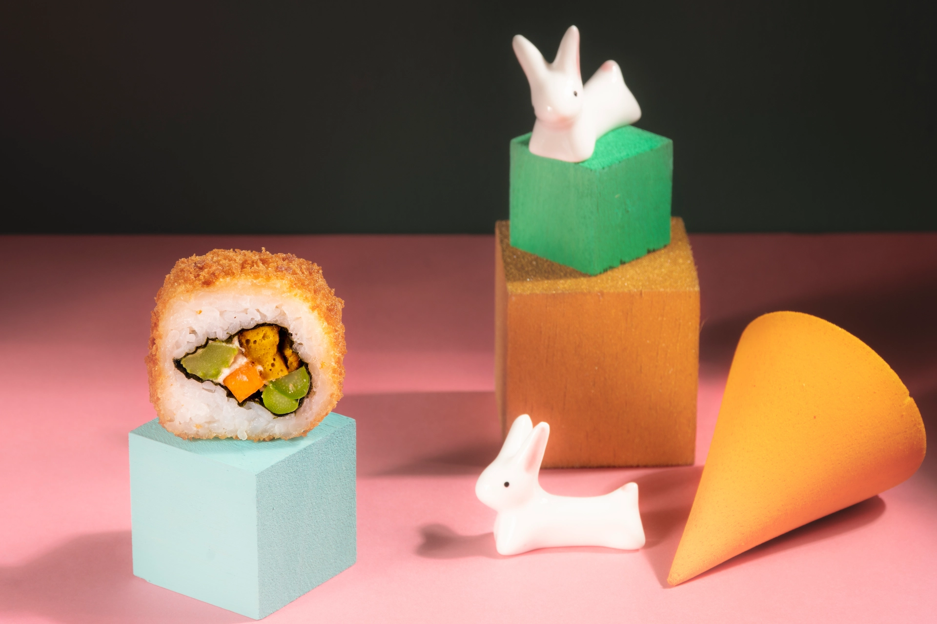 Fotografía gastronómica de Golden Roll de sushi sobre cubo decorativo en fondo rosado — Jose Fonseca Medellín