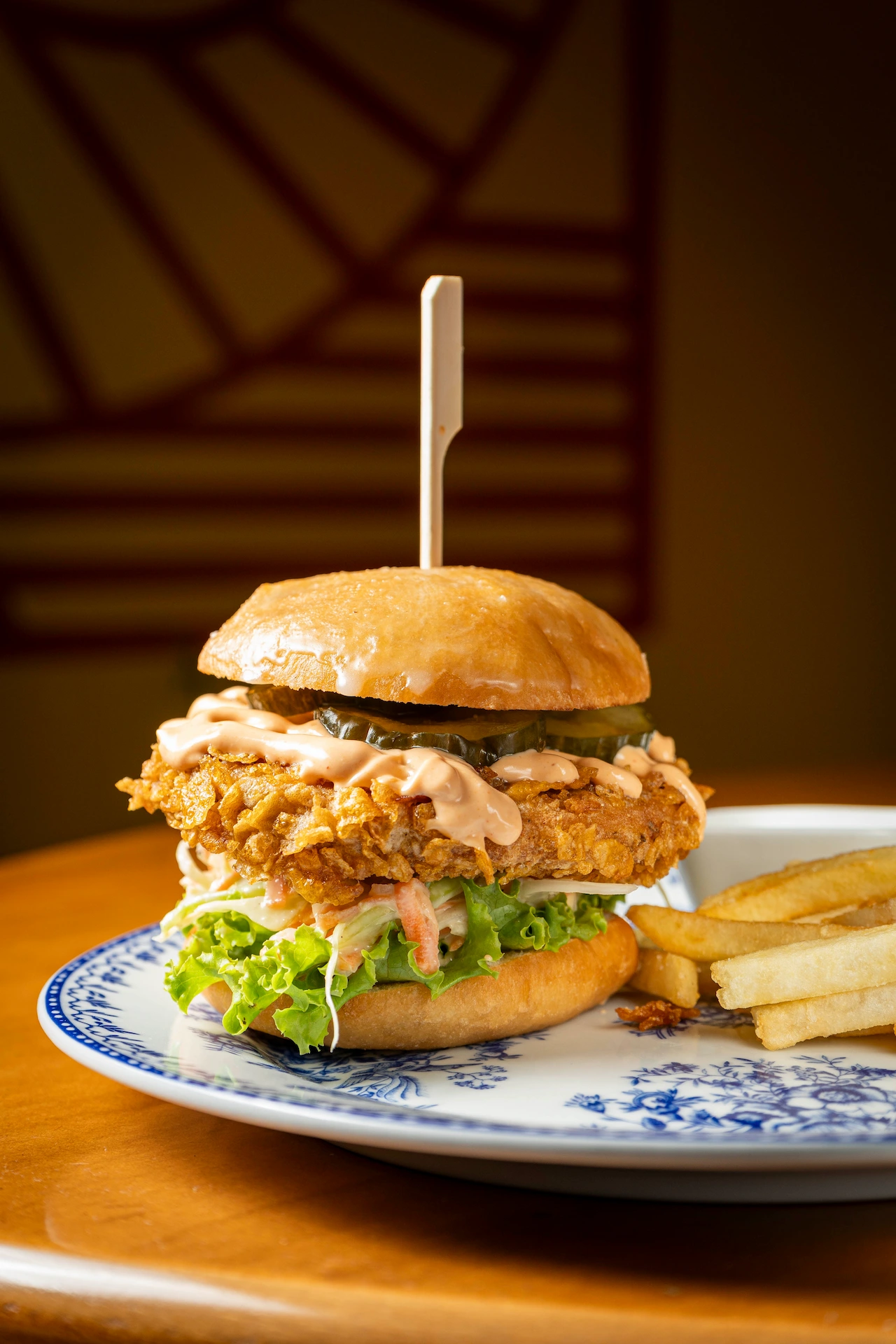 Fotografía gastronómica de hamburguesa plant based estilo crispy con salsa chipotle y papas fritas en plato azul — Jose Fonseca Medellín