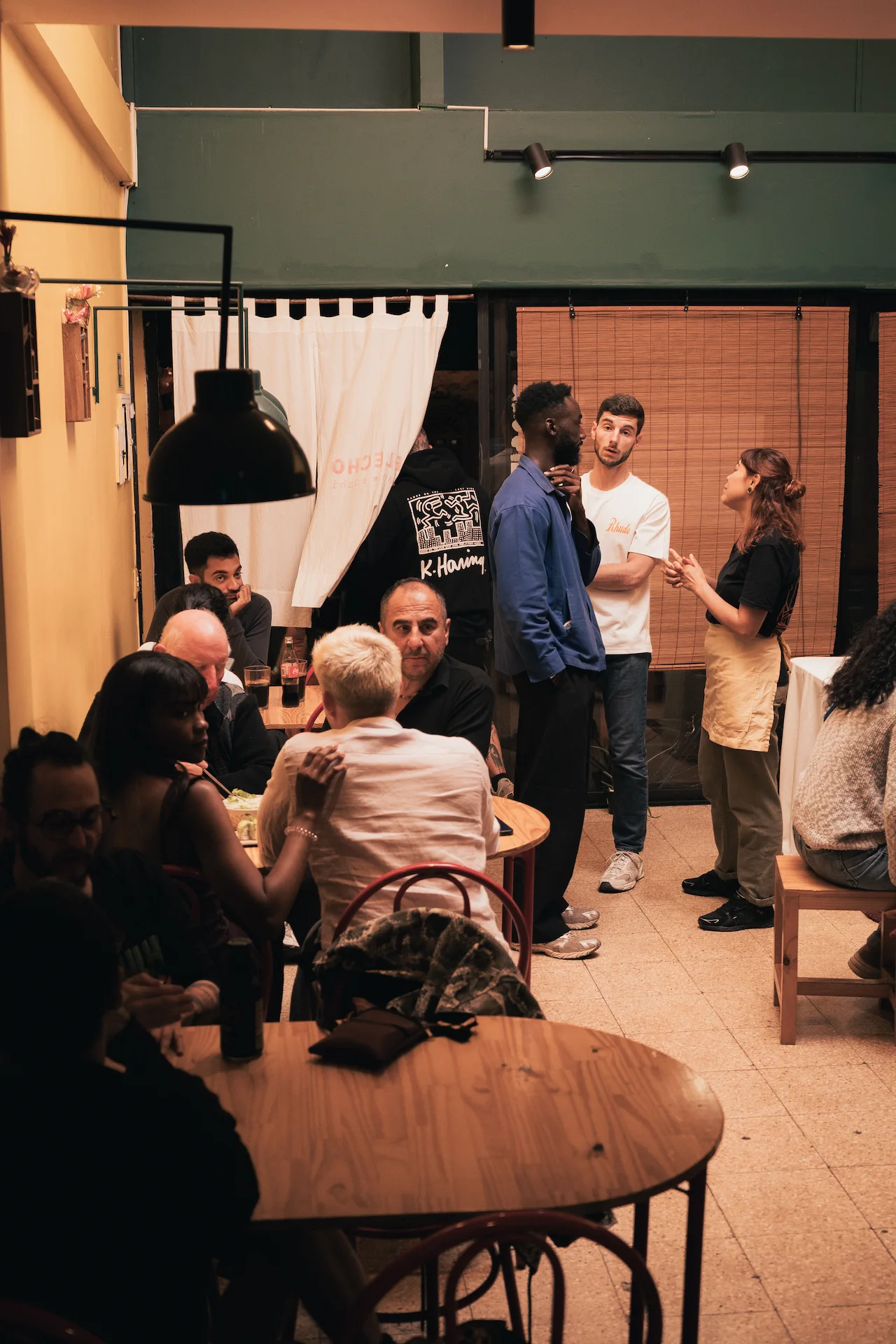 Fotografía gastronómica de interior de restaurante con comensales y personal en servicio, iluminación cálida y estética japonesa — Jose Fonseca Medellín