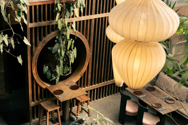 Fotografía gastronómica de patio de restaurante con lámpara farol, marco circular en madera y mesas con vajilla — Jose Fonseca Medellín