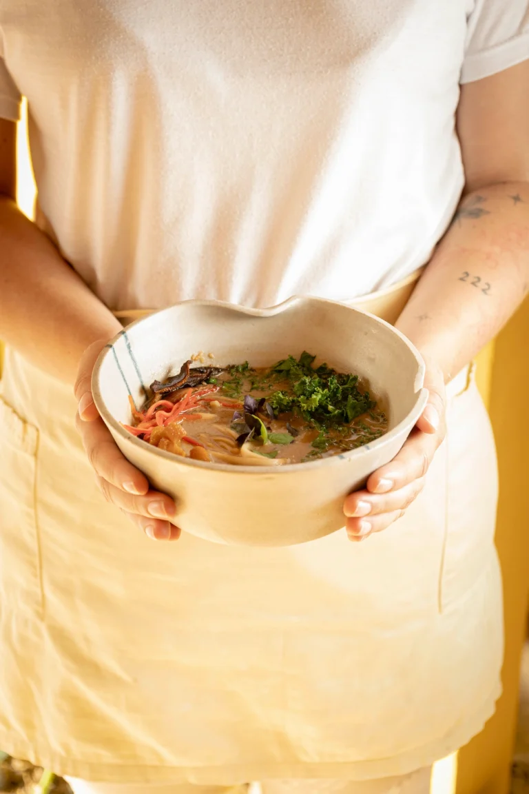 Fotografía gastronómica de ramen vegano con zanahoria, kale y champiñón en bowl artesanal sostenido por manos — Jose Fonseca Medellín