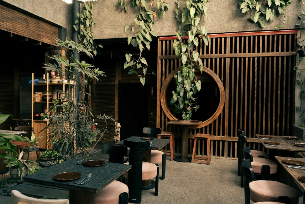 Fotografía gastronómica de terraza con marco circular decorativo, plantas trepadoras y mesas de madera — Jose Fonseca Medellín
