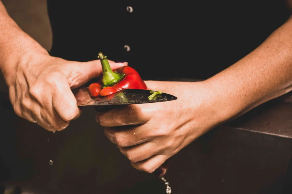 Manos de Gloria Inés con cuchillo y pimentón, cocina colombiana — Sin Receta